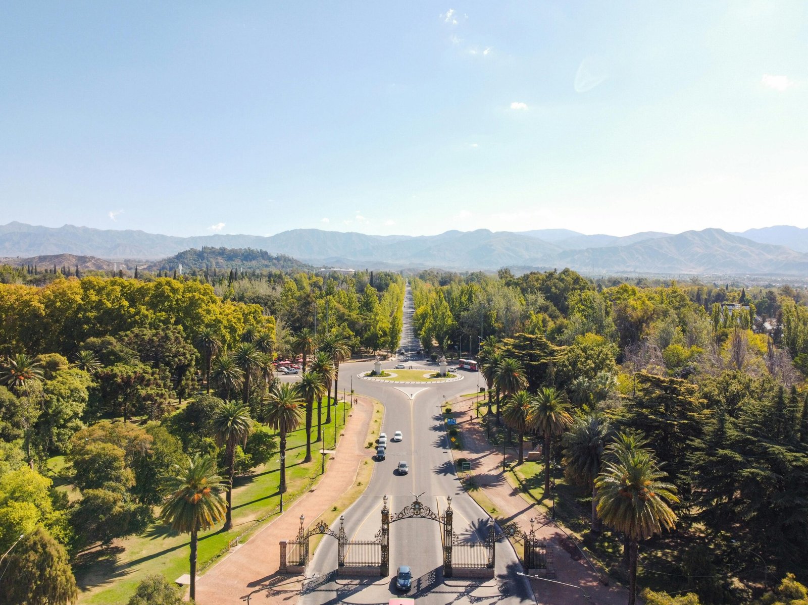 Captivating aerial view of a roadway surrounded by lush greenery and mountains in Mendoza, Argentina.