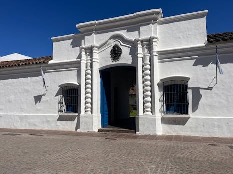 Front view of the historic Casa de Tucumán under clear blue skies in San Miguel de Tucumán, Argentina.